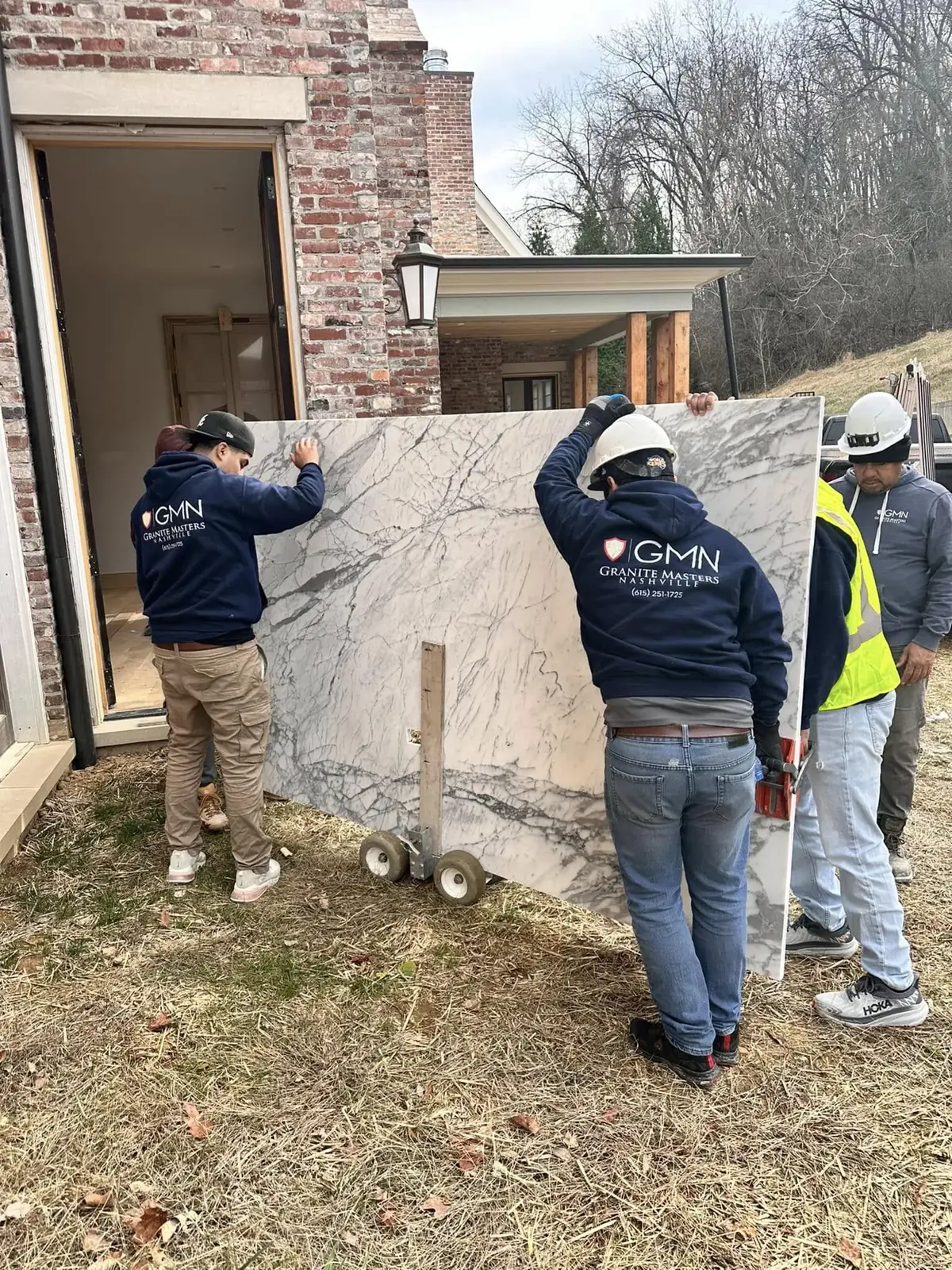 Granite Masters team handling a slab during installation